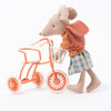 Maileg mouse holding on to the tricycle basket on coral tricycle